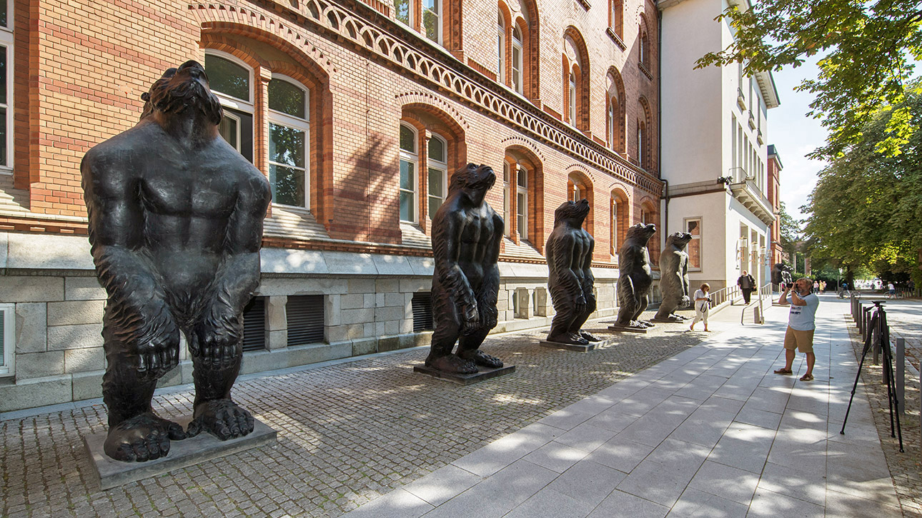 Rechts und links neben dem Eingangsportal stehen 3.60 Meter große  Gorilla-Skulpturen. Zahlreiche passanten bewundern und fotografieren die Bronze-Plastiken. 