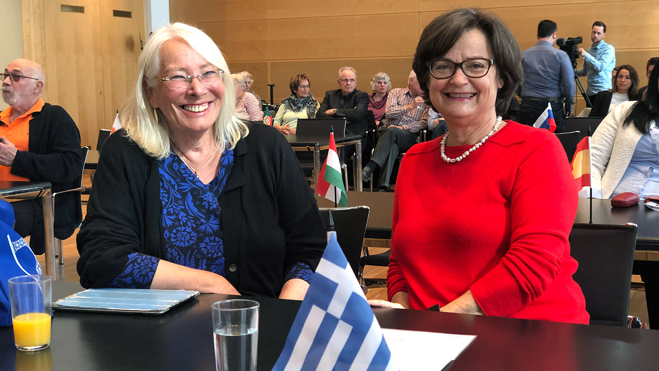 Zwei Frauen, die ursprünglich aus Frankreich und Griechenland stammen, sprechen bei einer EU-Veranstaltung im Landeshaus.