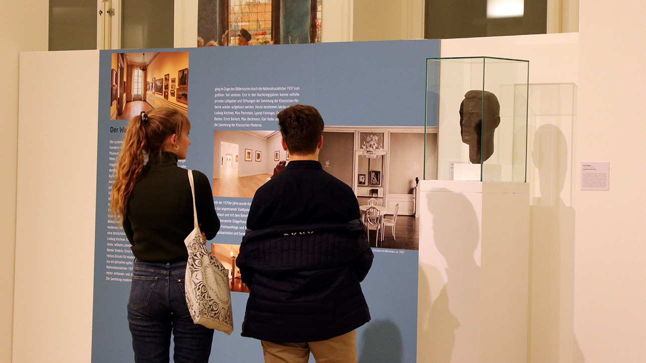 Zwei Besucher schauen sich eine Ausstellung im Landeshaus an.