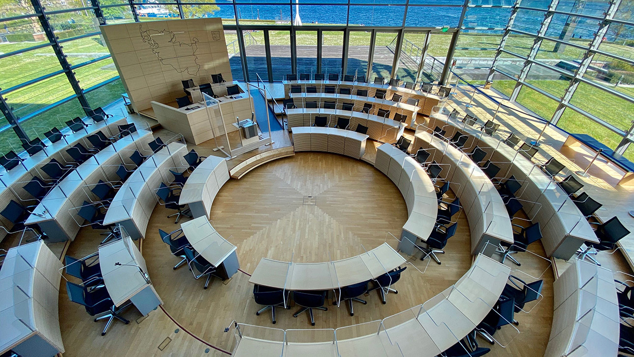 Blick in den leeren Plenarsaal mit neuen Schutzkonstruktionen aus Acrylglas.