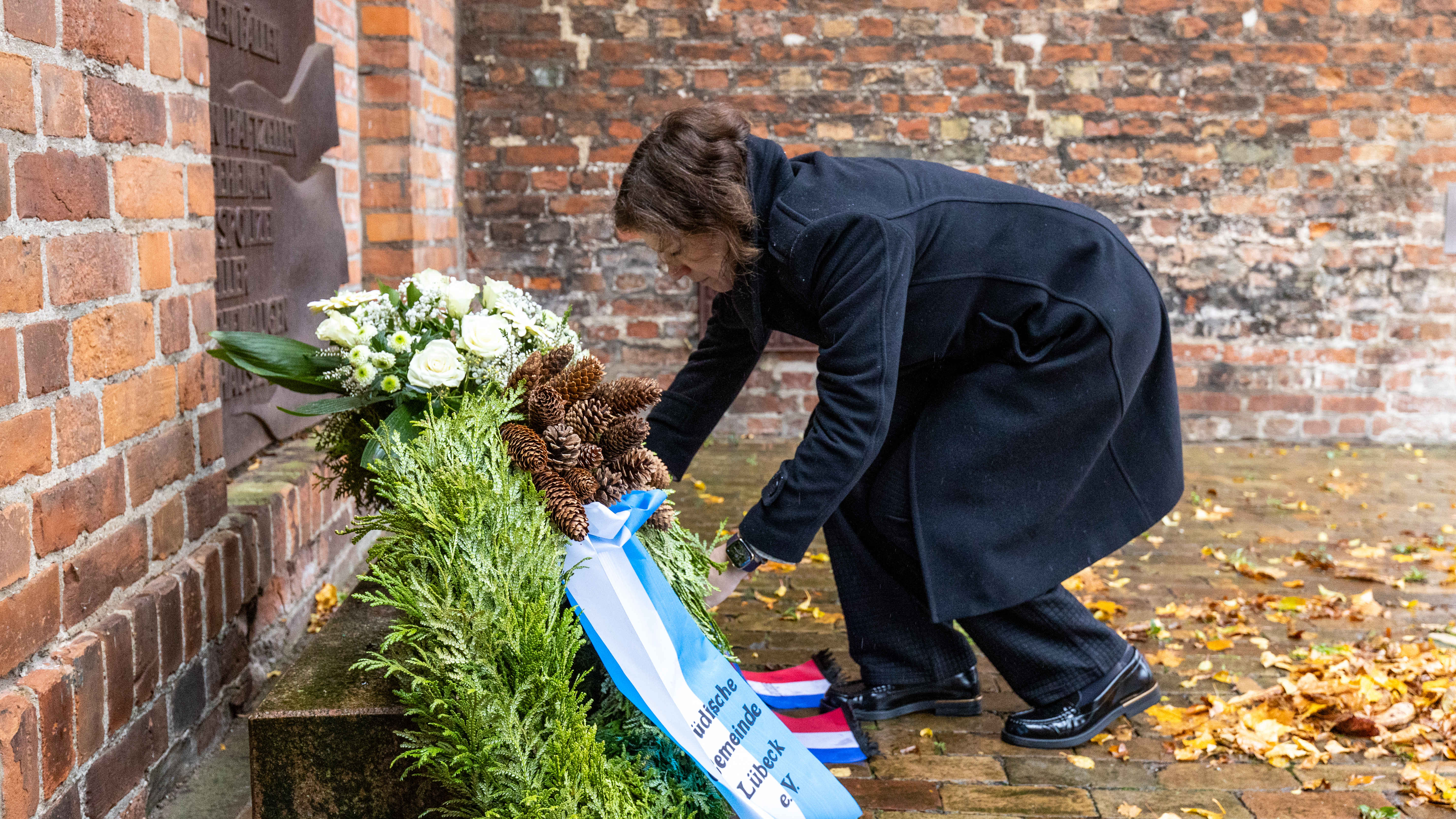 Landtagspräsidentin Kristina Herbst legt einen Kranz an der Lübecker Synagoge nieder