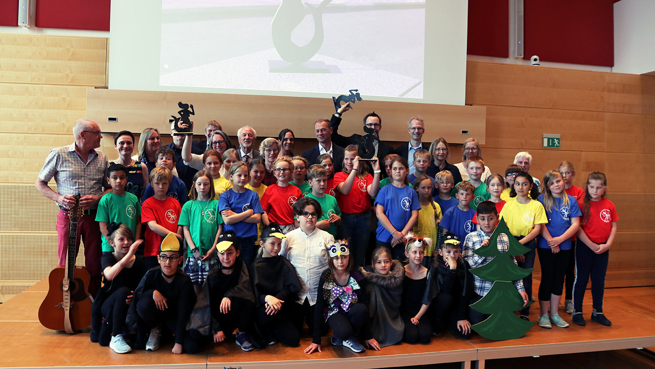 Gruppenfoto aller diesjährigen „Emmi“-Preisträger auf der Bühne im Schleswig-Holstein-Saal des Landtages.