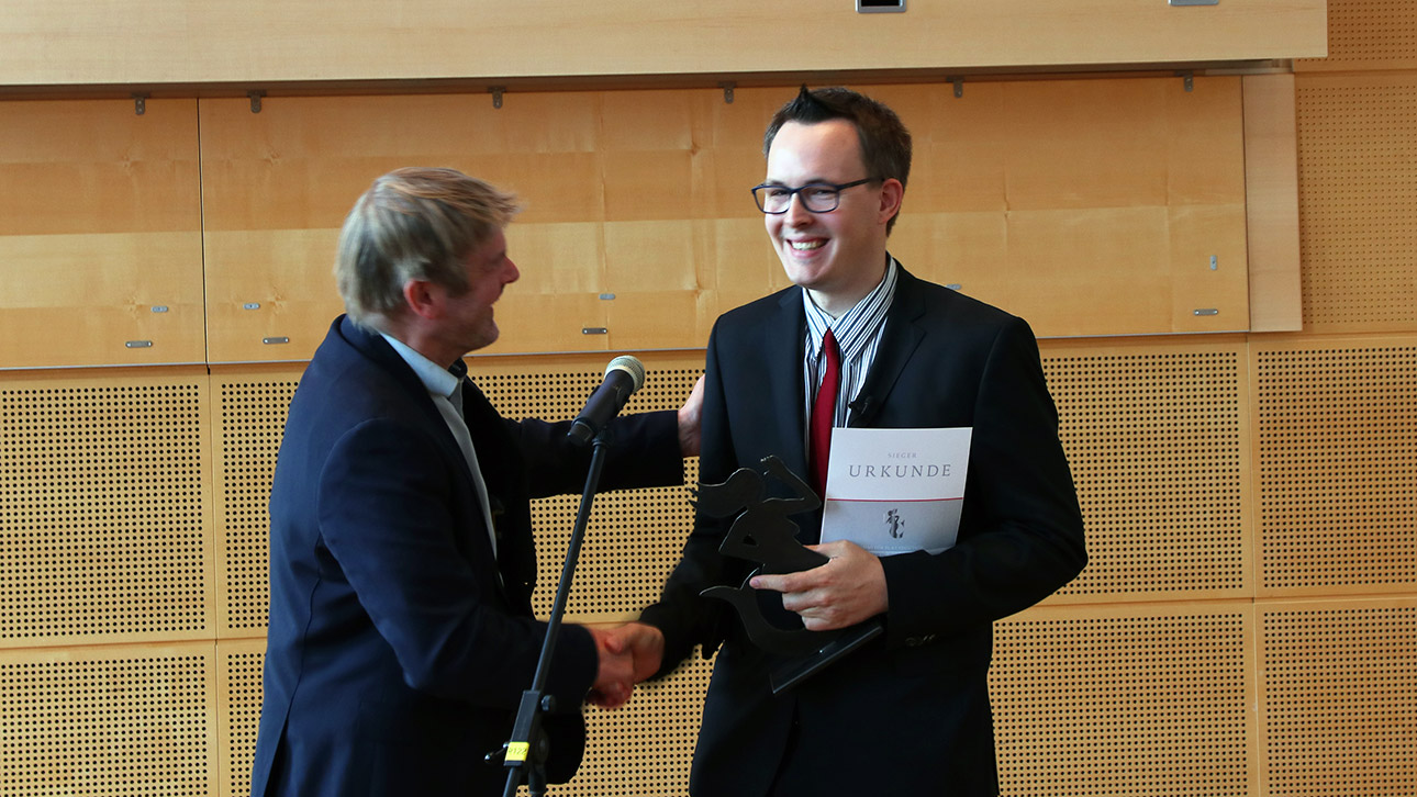 Der Student Julian M. Teske bekommt seine „Emmi“ von Jan Graf vom Schleswig-Holsteinischen Heimatbund überreicht.überreicht.