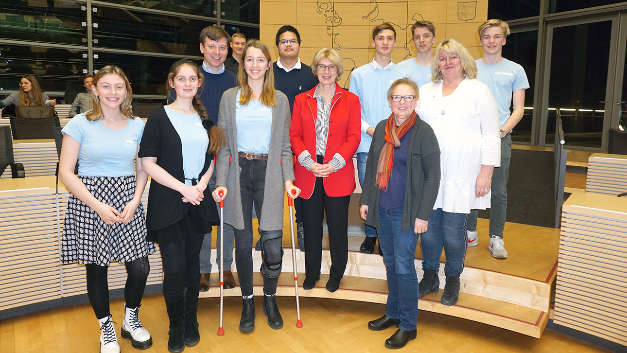 Anita Klahn (FDP, Bildmitte) mit weiteren Bildungspolitikerinnen und -politikern sowie Schülervertreterinnen und -vertretern im Plenarsaal