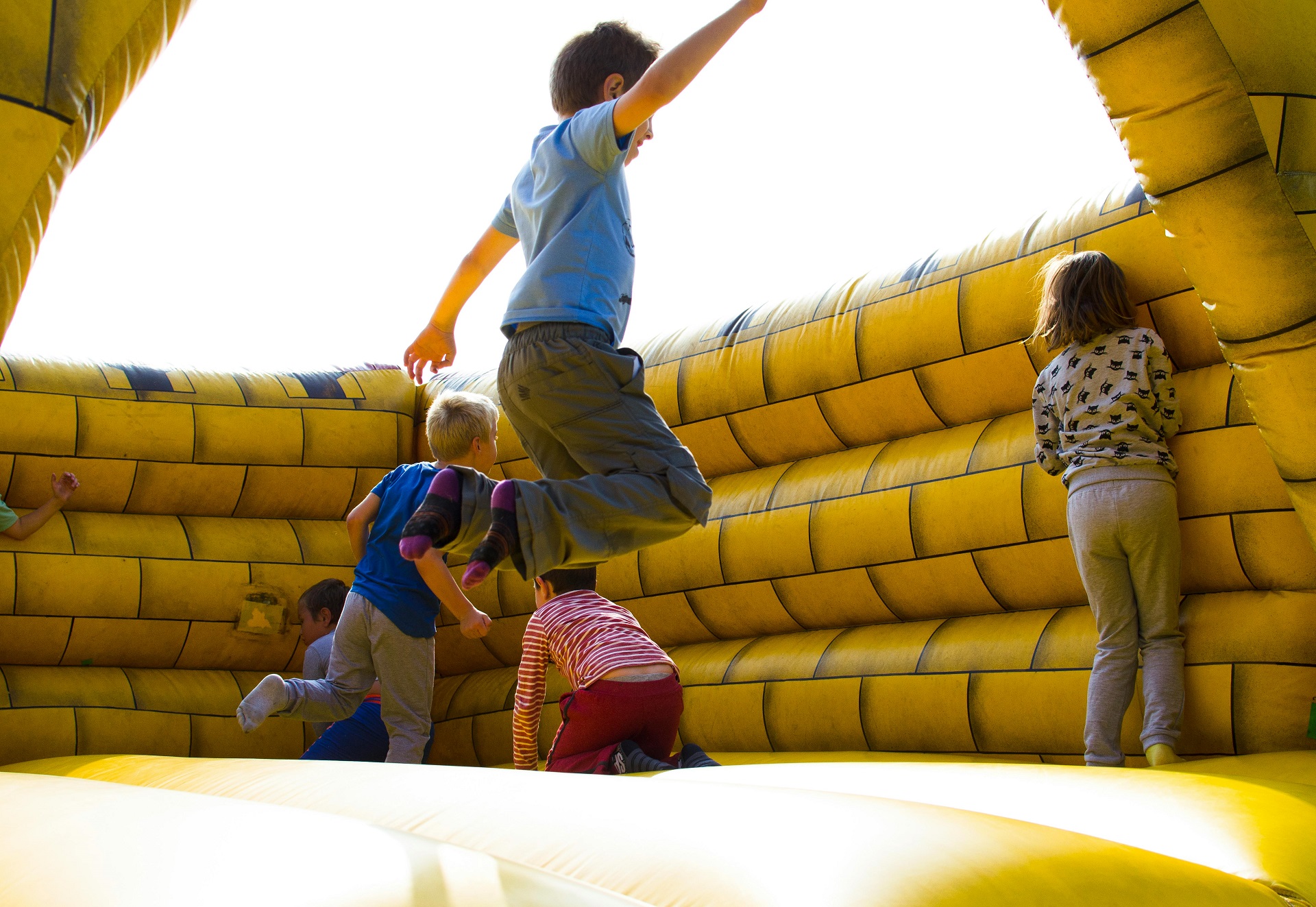 Kinder springen in einer gelben Hüpfburg