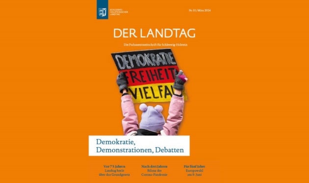 Blick auf das Cover der Landtagszeitschrift auf dem ein Mädchen ein Schild in den Farben der Bundesrepublik mit der Aufschrift "Demokratie, Freiheit, Vielfalt" hochhält.