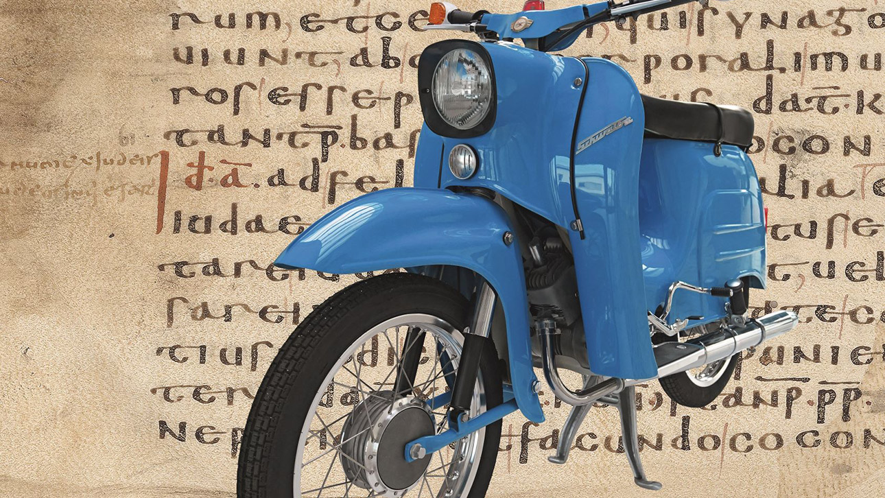 Ein blaues Simson-Motorrad vor einem Edikt von Kaiser Konstantin aus dem Jahr 321.