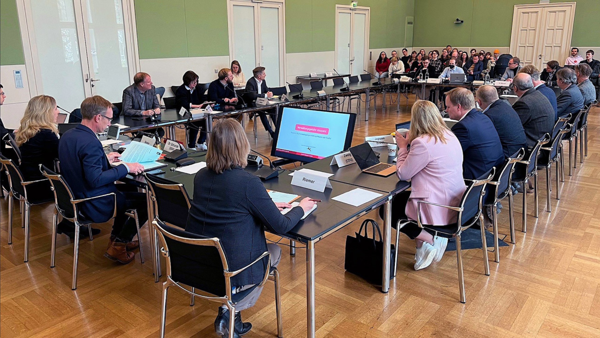 Studenten, Abgeordnete und Regierungsvertreter diskutieren im gut besuchten Ausschusssaal des Landtages.