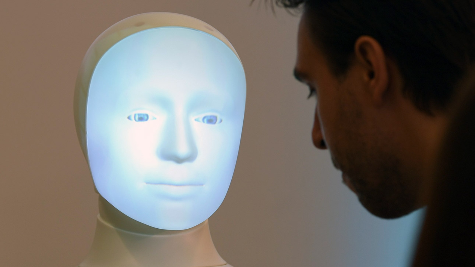 Ein wissenschaftlicher Mitarbeiter kommuniziert während einer Pressekonferenz an der TU Darmstadt mit Roboter "Alfie", einer Moral Choice Machine. 