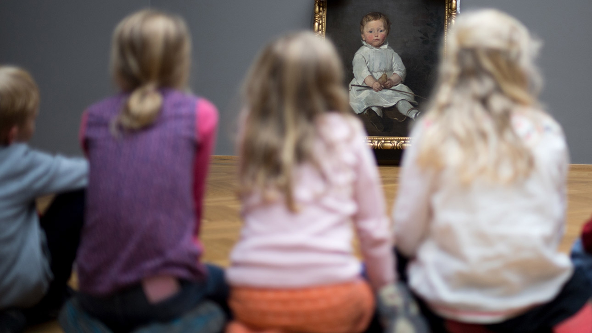 Kinder betrachten ein Gemälde in einem Museum.