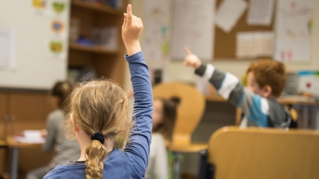 Schüler melden sich im Unterricht.