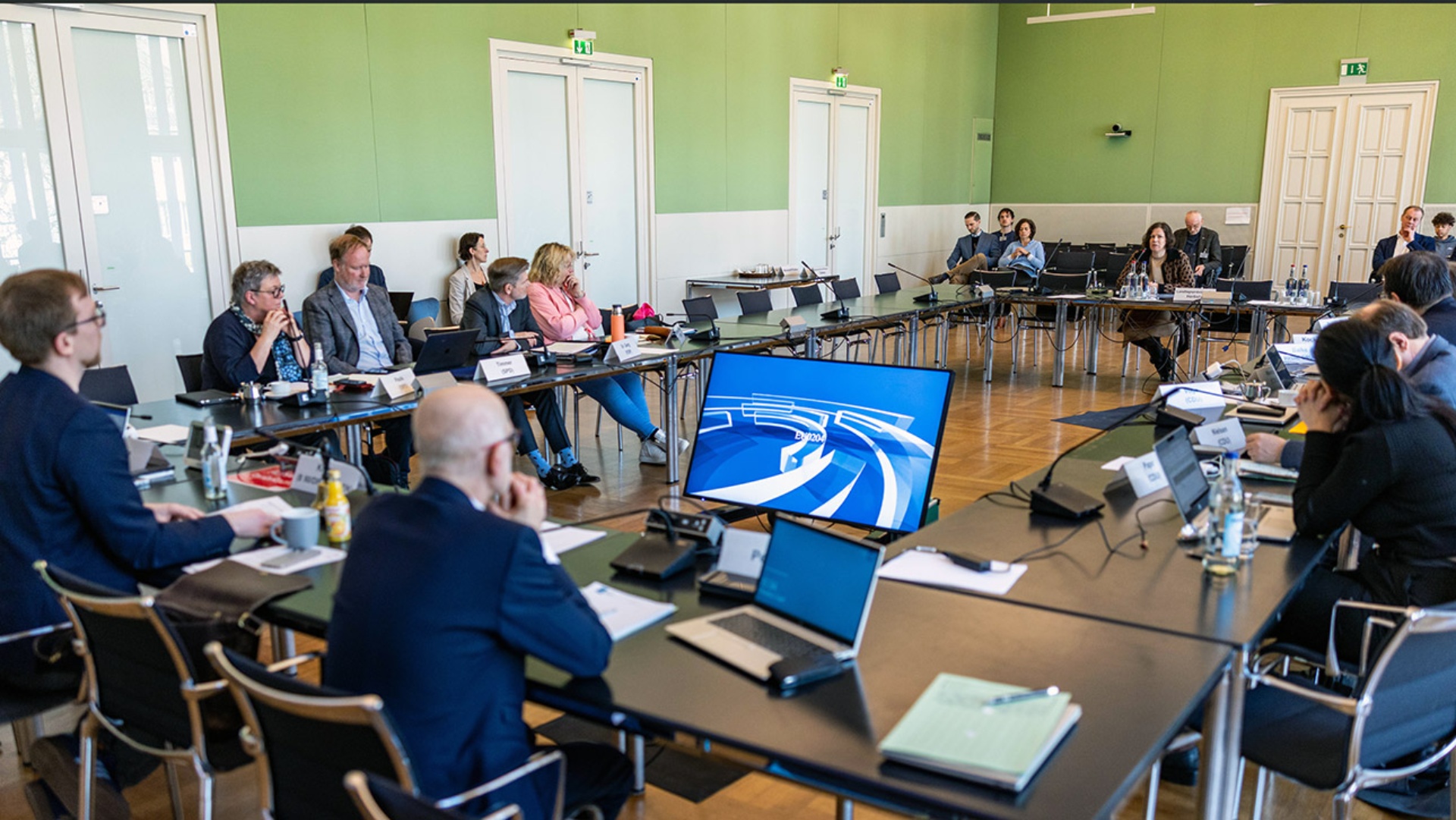 Landtagspräsident Kristina Herbst berichtet den im Ausschusssaal des Landtages sitzenden Abgeordneten über die Ältestenratsreise ins Baltikum.