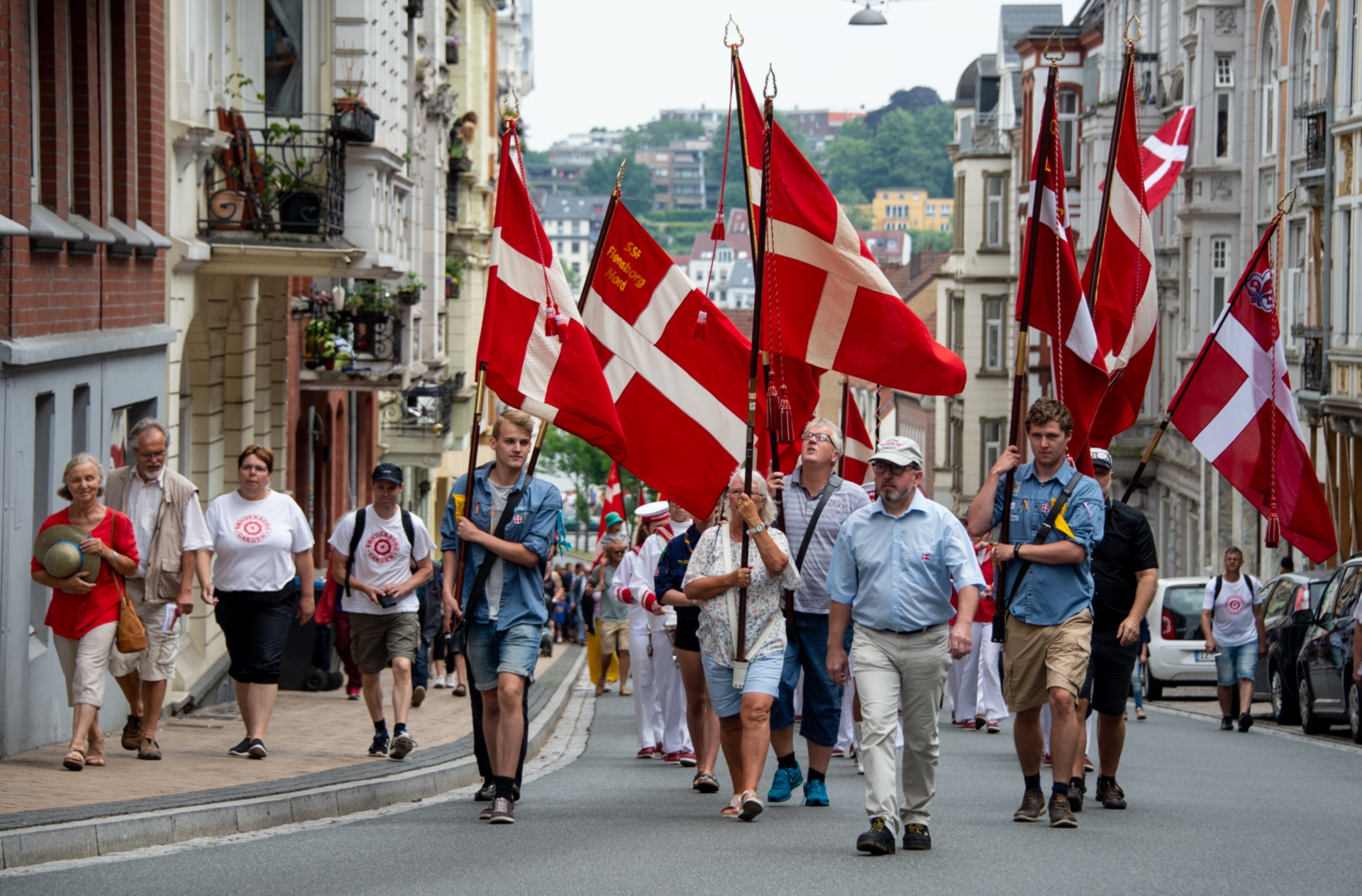 Fahnenträger mit  dänischen Flaggen führen im Juni 2018 einen Umzug durch die Flensburger Innenstadt beim Deutsch-Dänisches Jahrestreffen an. 