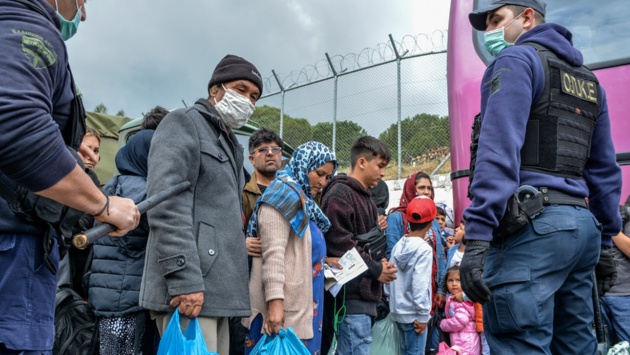 Migranten warten vor dem Lager Moria auf der griechischen Insel Lesbos auf Busse.