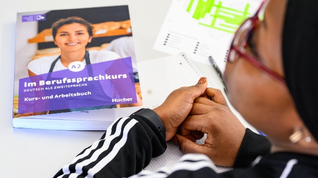 Eine Frau sitzt in einem Sprachkurs für Deutsch als Zweitsprache