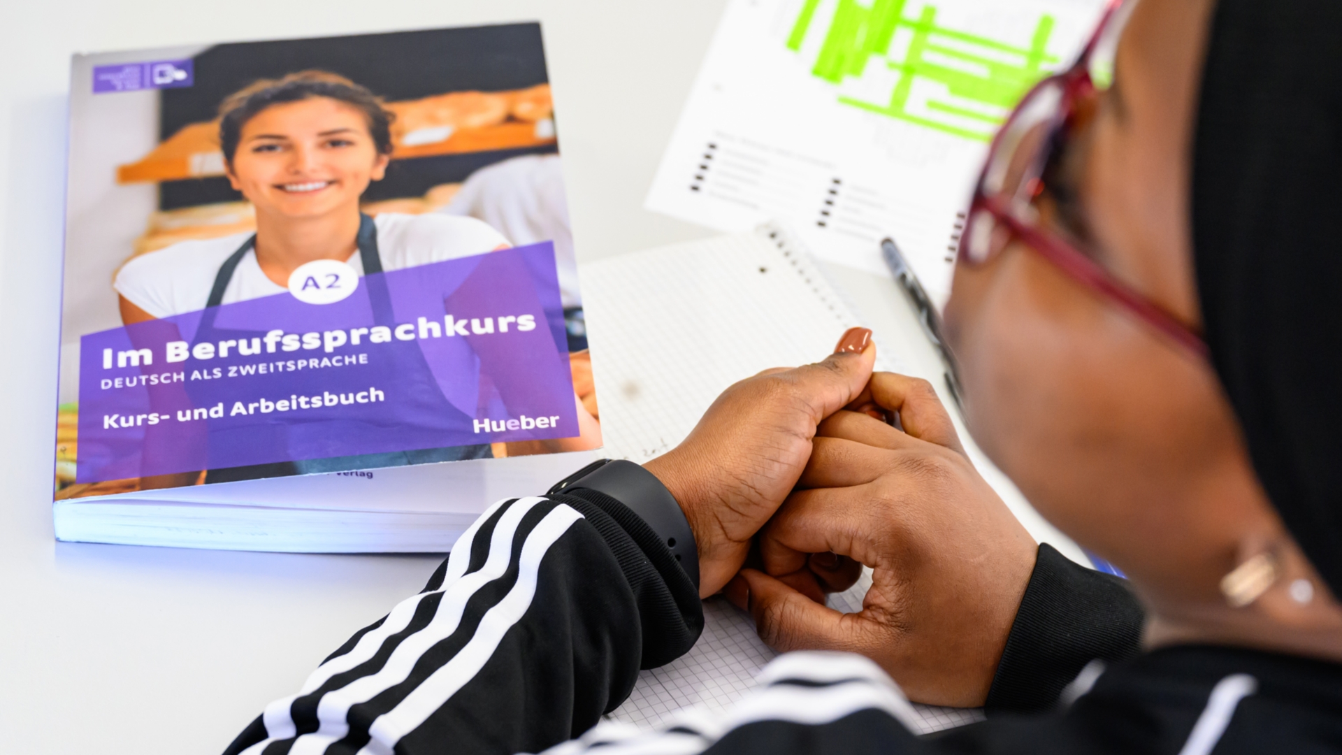 Eine Frau sitzt in einem Sprachkurs für Deutsch als Zweitsprache