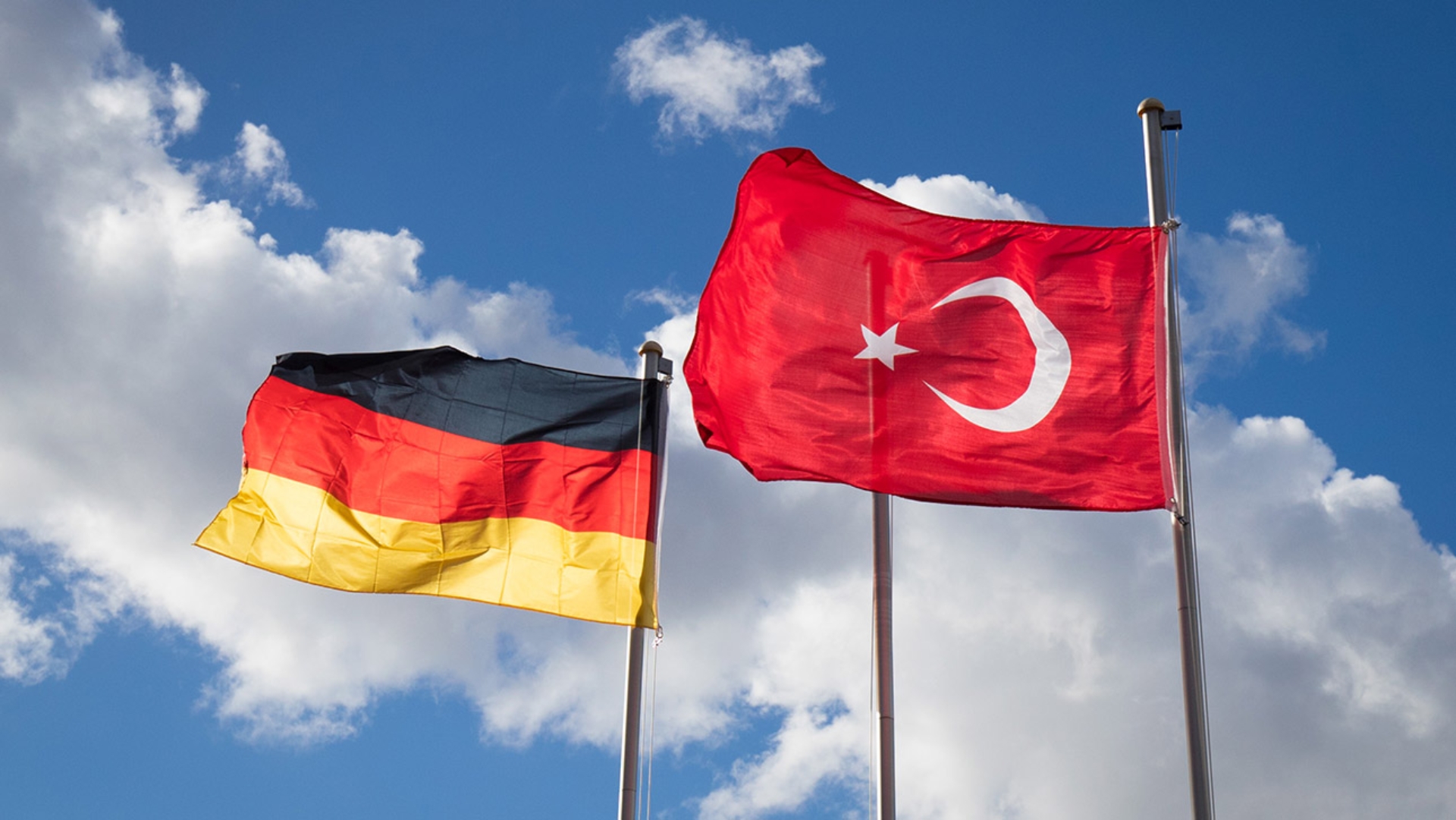Die deutsche und die türkische Flagge wehen an Fahnenmasten