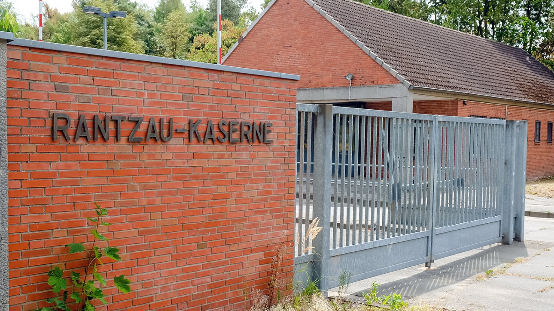 Am Eingang der Landesunterkunft für Flüchtlinge in Boostedt hängt ein Schild mit dem Schriftzug „Rantzau-Kaserne“.