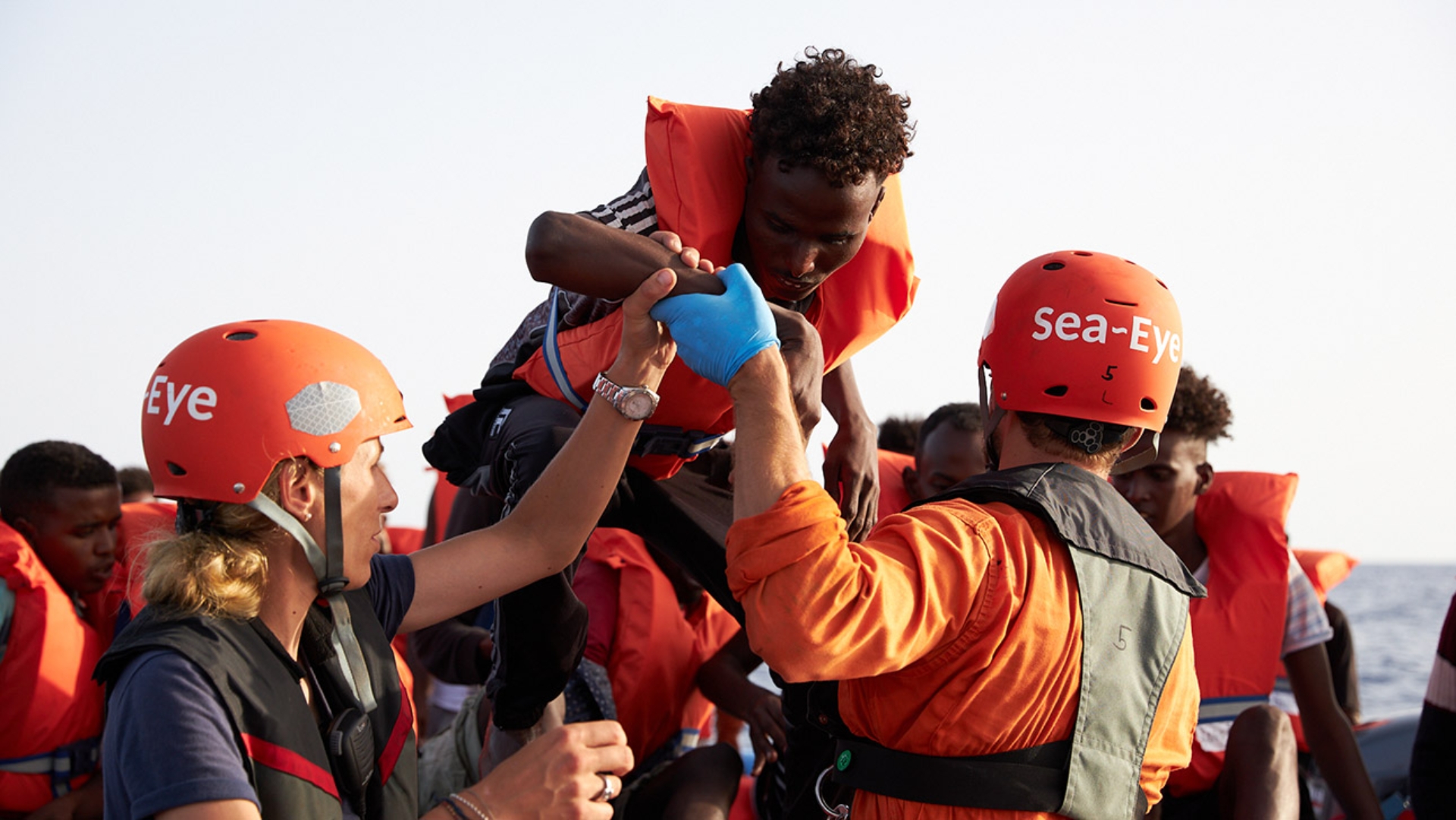  Mittelmeer: Die von der Seenotrettungsorganisation Sea-Eye herausgegebene Aufnahme zeigt Seenotretter, die Flüchtlinge im Mittelmeer von einem Schlauchboot evakuieren.
