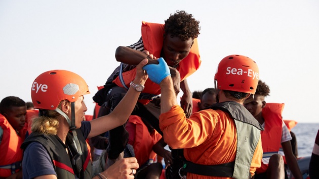  Mittelmeer: Die von der Seenotrettungsorganisation Sea-Eye herausgegebene Aufnahme zeigt Seenotretter, die Flüchtlinge im Mittelmeer von einem Schlauchboot evakuieren.