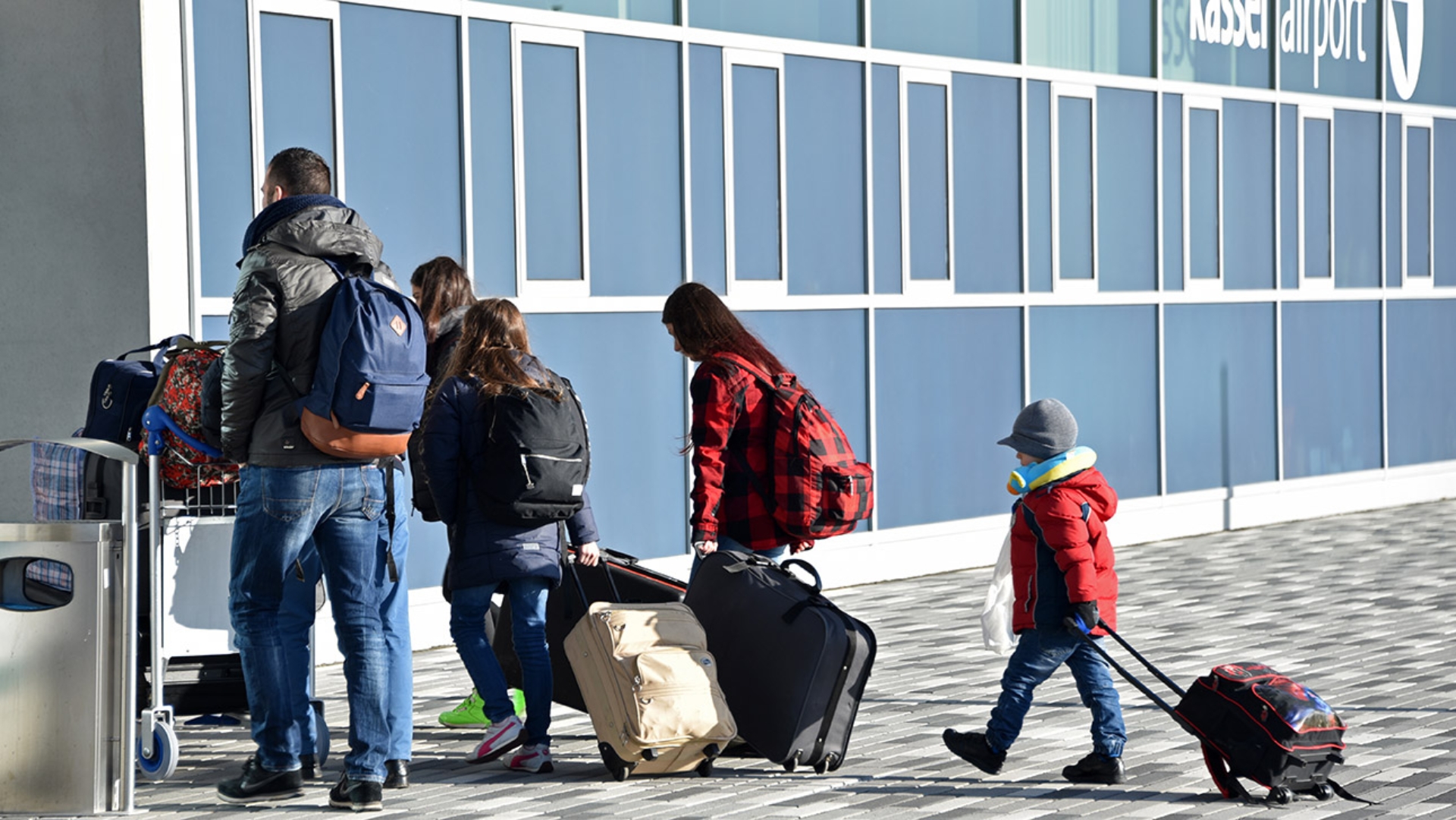 Eine Flüchtlingsfamilie mit Gepäck am Flughafen