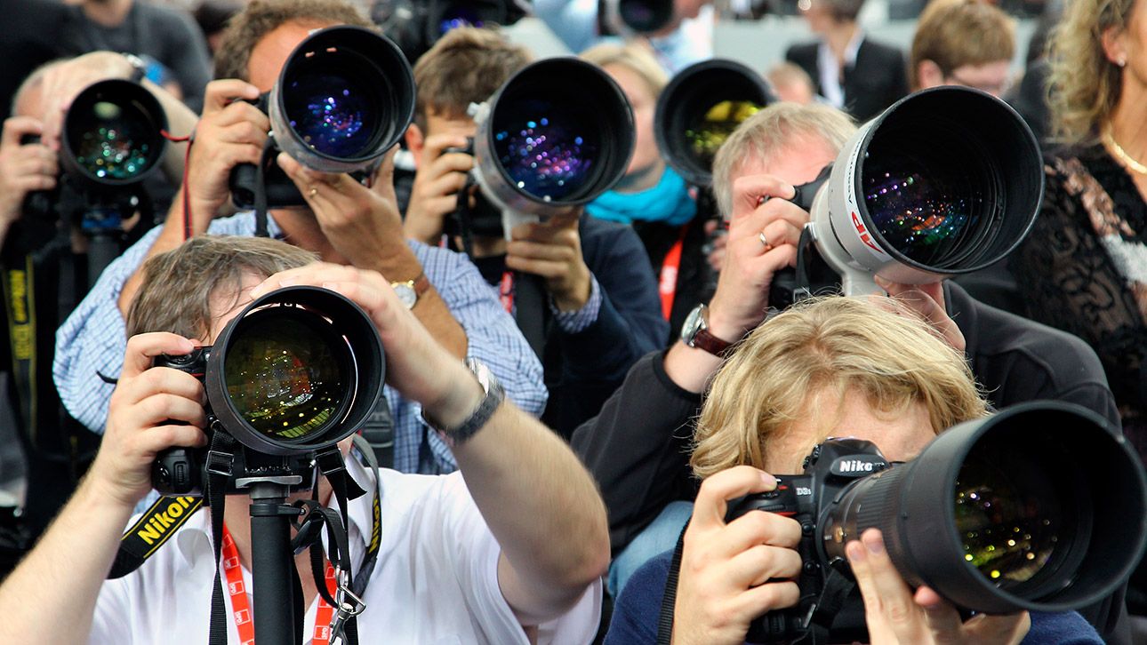 Fotografen gucken auf einer Pressekonferenz durch ihre Kameras.