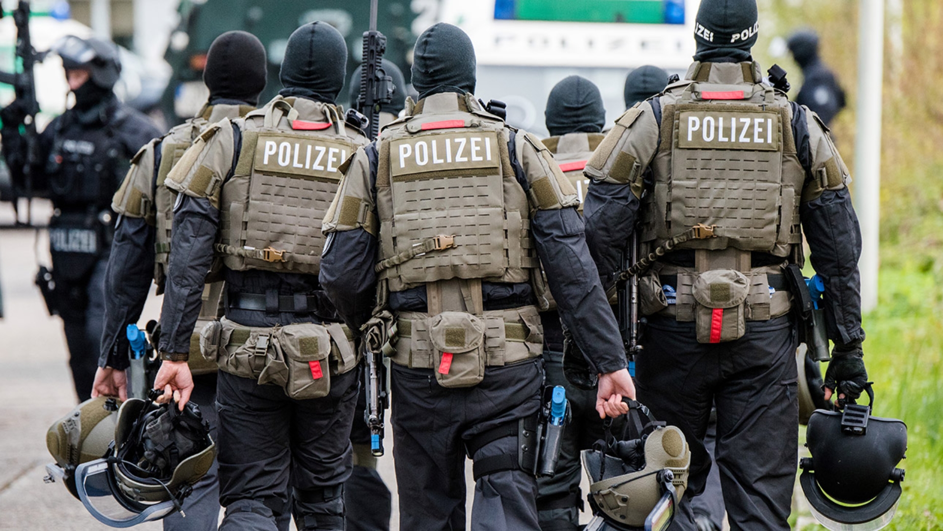 Schwer bewaffnete Polizisten gehen während einer Anti-Terror-Übung zu ihren Fahrzeugen