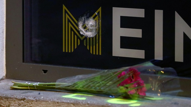 Rosen liegen unter einem Einschussloch in einer Scheibe im Bereich des Tatorts einer Terror-Attacke in der Nähe einer Synagoge.