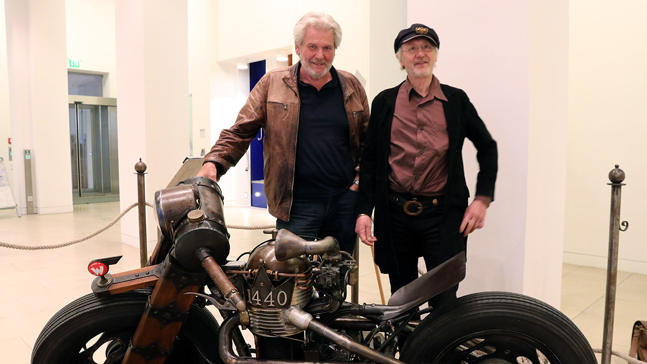 Special Guest ist Rötger „Brösel“ Feldmann (rechts). Der „Werner“-Zeichner stellt das Kult-Motorrad „Satte Literschüssel“ für die Ausstellung zu Verfügung. Auch Gastronom und Galerist Holger Henze (links) besuchte die Ausstellungseröffnung. Er ist Besitzer des Red Porsche Killers, bekannt aus den 