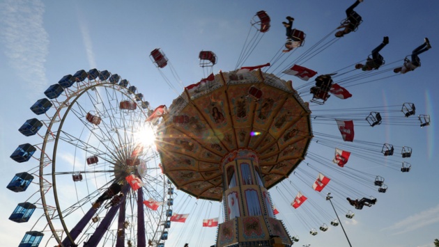 Blick auf ein Kettenkarussell mit Riesenrad im Hintergrund