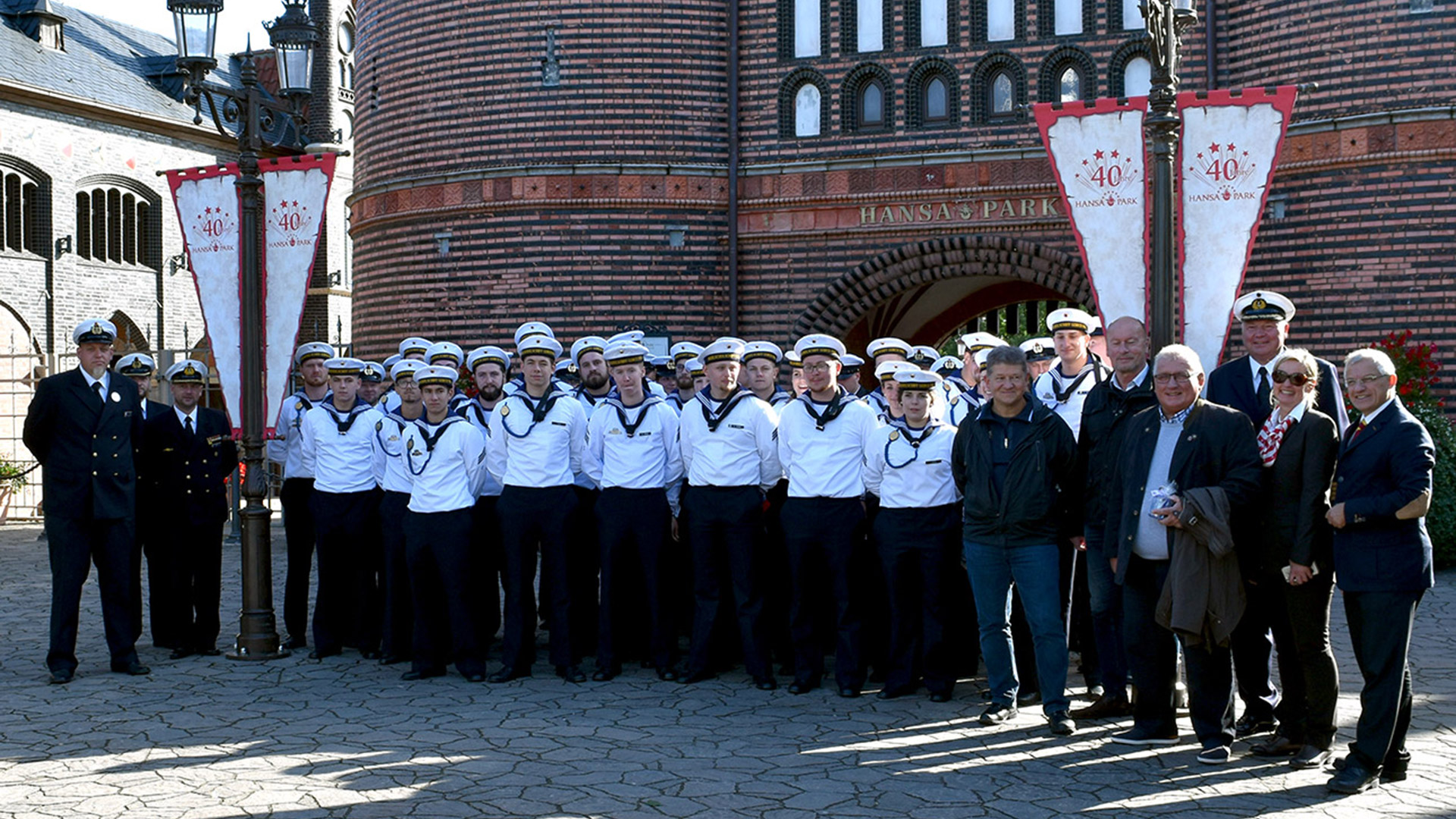 Die Stambesatzung der Gorch-Fock, Landtagspräsident Schlie und Abgeordnete vor dem Eingang des Hansa-Parks