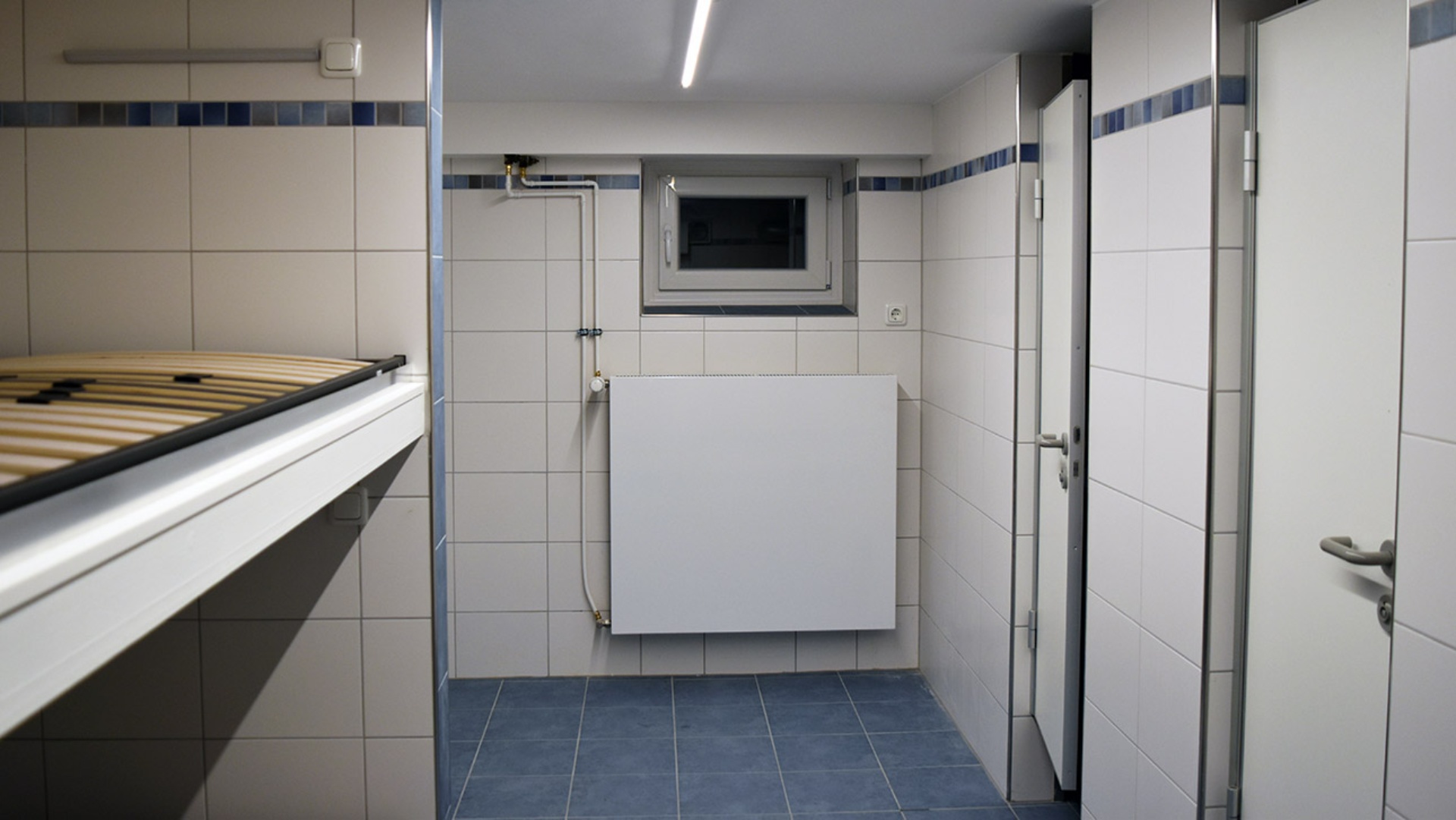 Die  sanierte, weiß geflieste Obdachlosen-Unterkunft in der Kieler St. Heinrich-Kirchengemeinde mit Doppelstockbetten und Sanitärräume.