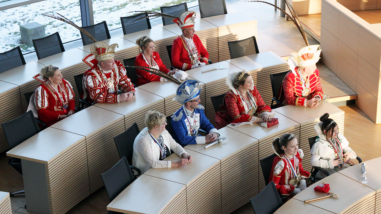 Verkleidete Menschen sitzen im Plenarsaal.