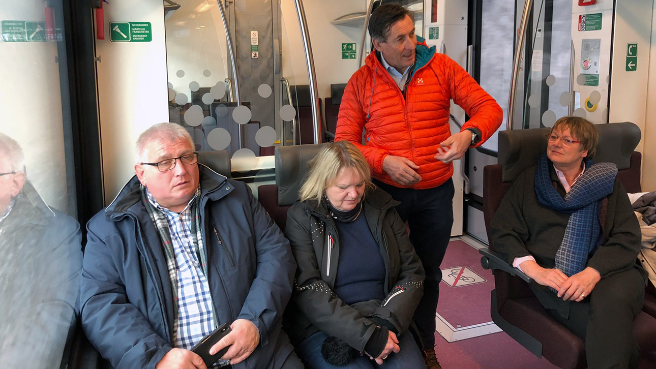 Vier Politiker sitzen in einem Zug.