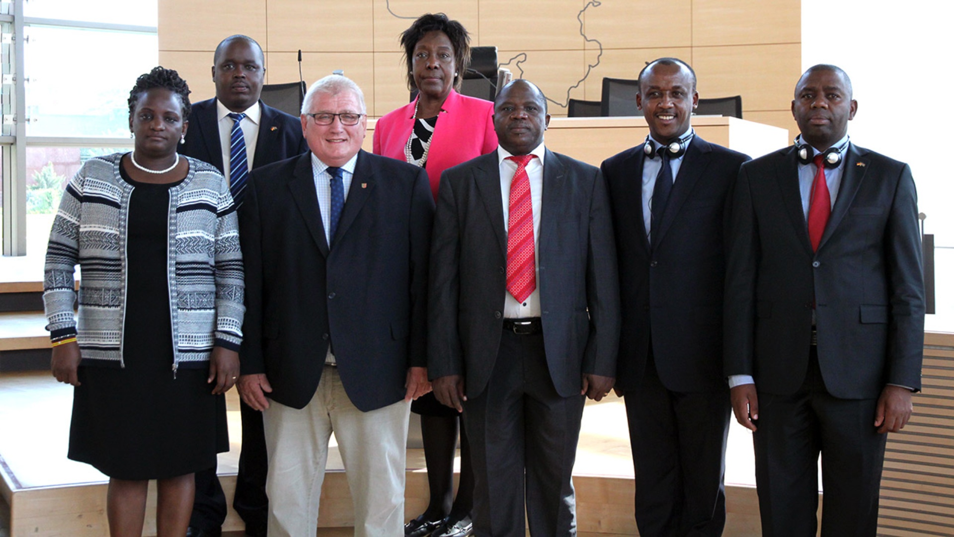 Sechs Politiker aus Kenia stehen mit Landtagspräsident Schlie im Plenarsaal.