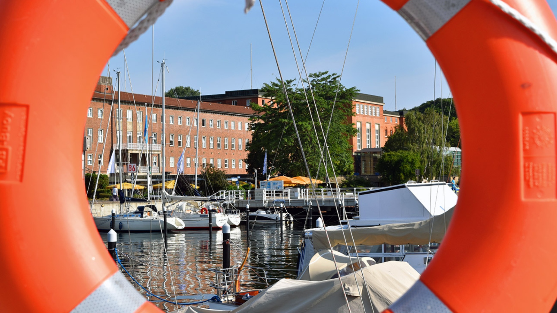 Durch einen Rettungsring fällt der Blick auf das Landeshaus.