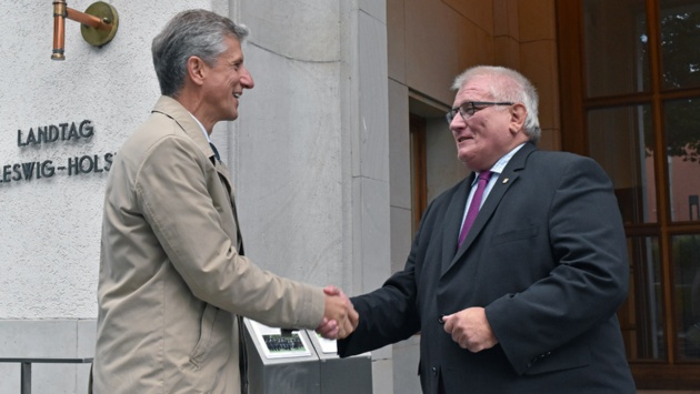 Der Botschafter von Litauen schüttelt Landtagspräsident Schlie zur Begrüßung die Hand.