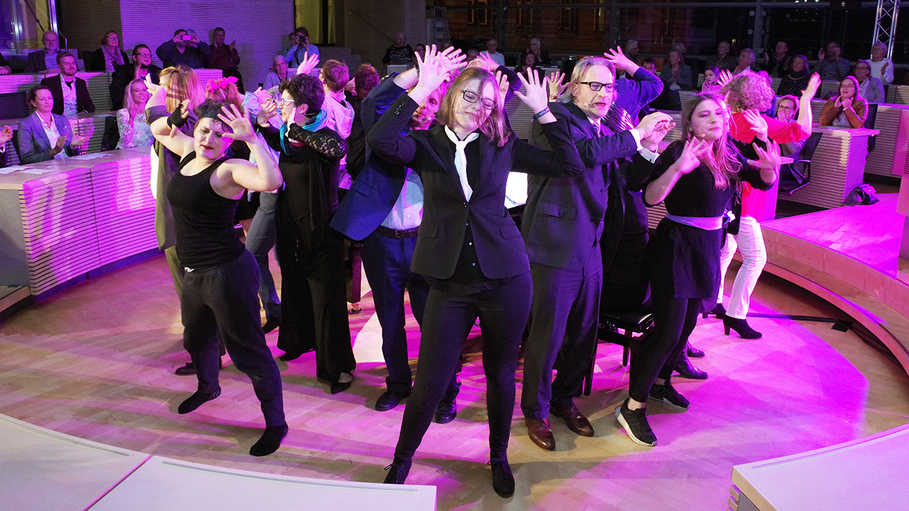 Darsteller der Musical Academy Schleswig-Holstein stehen Rücken an Rücken im Plenarsaal.