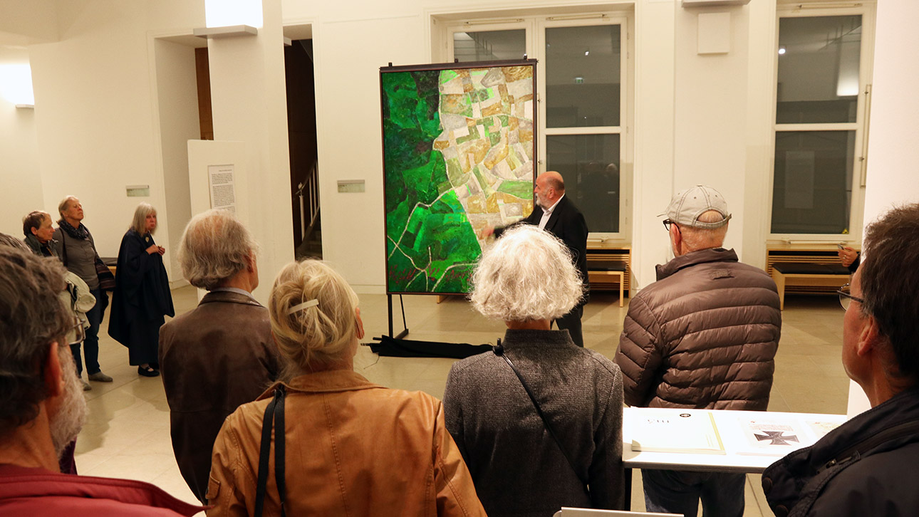 Uwe Appold präsentiert den Besuchern das erste Gemälde seines Bilderzyklus mit dem Titel „Das Schlachtfeld“. (11.10.)