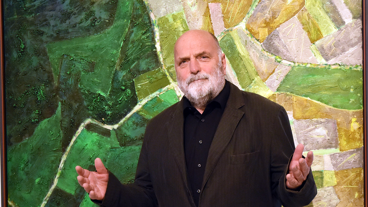 Der Maler Uwe Appold im Porträt vor einem Ausschnitt seines großformatigen Bildes "Das Schlachtfeld".