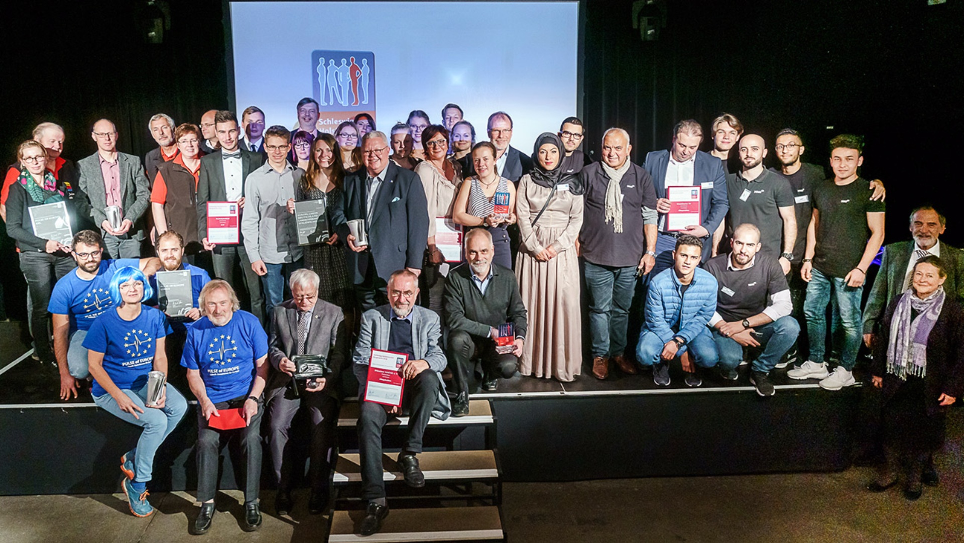 Alle Gewinner des Bürgerpreises und des Demokratiepreises auf der Bühne im Güterbahnhof in Kiel.