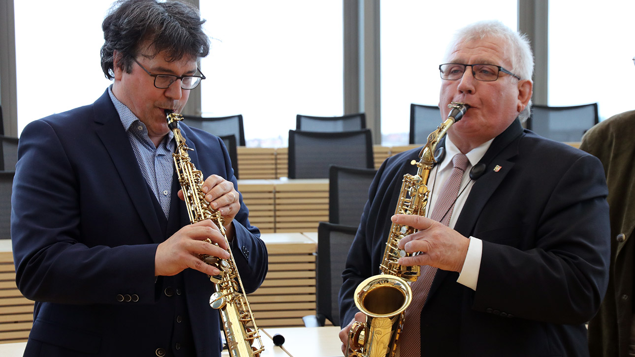 Landtagspräsident Klaus Schlie (rechts) und Musiker Rico Gubler spielen auf dem Saxophon.