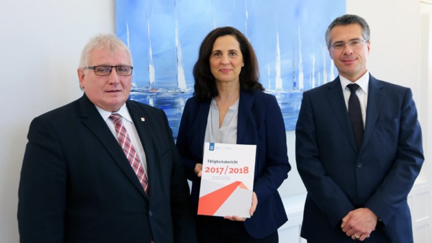 Gruppenfoto bei der Übergabe: Samiah El-Samadoni hält ihren Tätigkeitsbericht hoch, bevor sie ihn an Landtagspräsident Klaus Schlie übergibt. Mit auf dem Foto ist Landtagsdirektor Utz Schliesky.