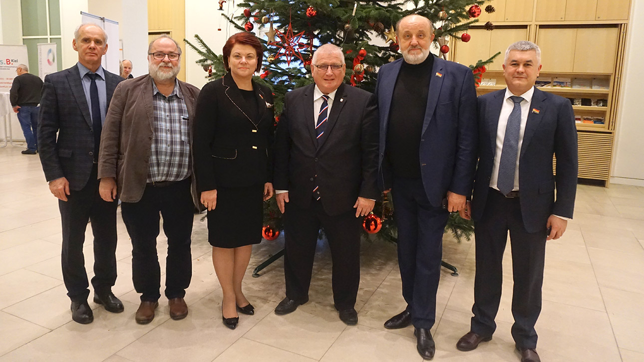 Eine Delegation aus Kaliningrad posiert mit Landtagspräsident Klaus Schlie in der Eingangshalle des Landtages.