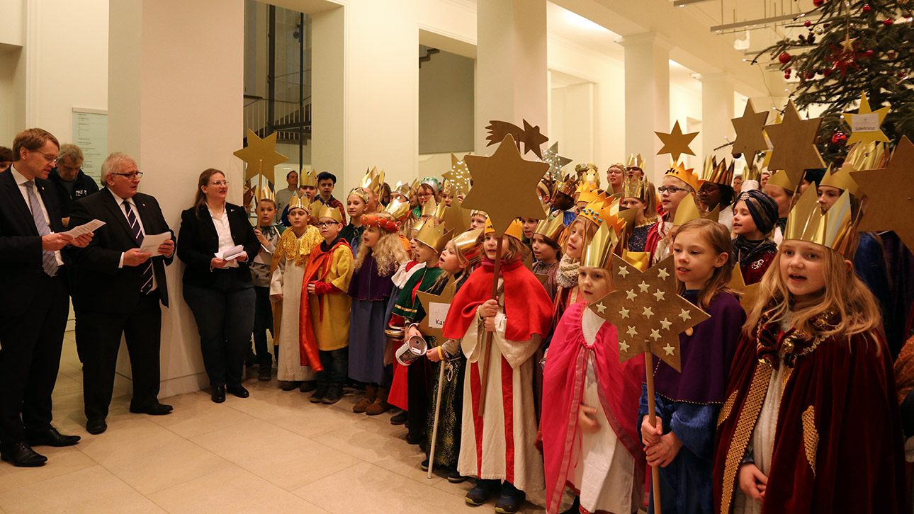 ...ging es in die Eingangshalle des Parlaments, wo die rund 80 Sternsinger mit Landtagspräsident Klaus Schlie (2.v.li.) und CDU-Ministerpräsident Daniel Günther ein christliches Lied sangen. Anschließend spendeten die Politiker für die Sammelaktion der Sternsinger, die in diesem Jahr bedürftigen Kindern im Libanon zugute kommt.