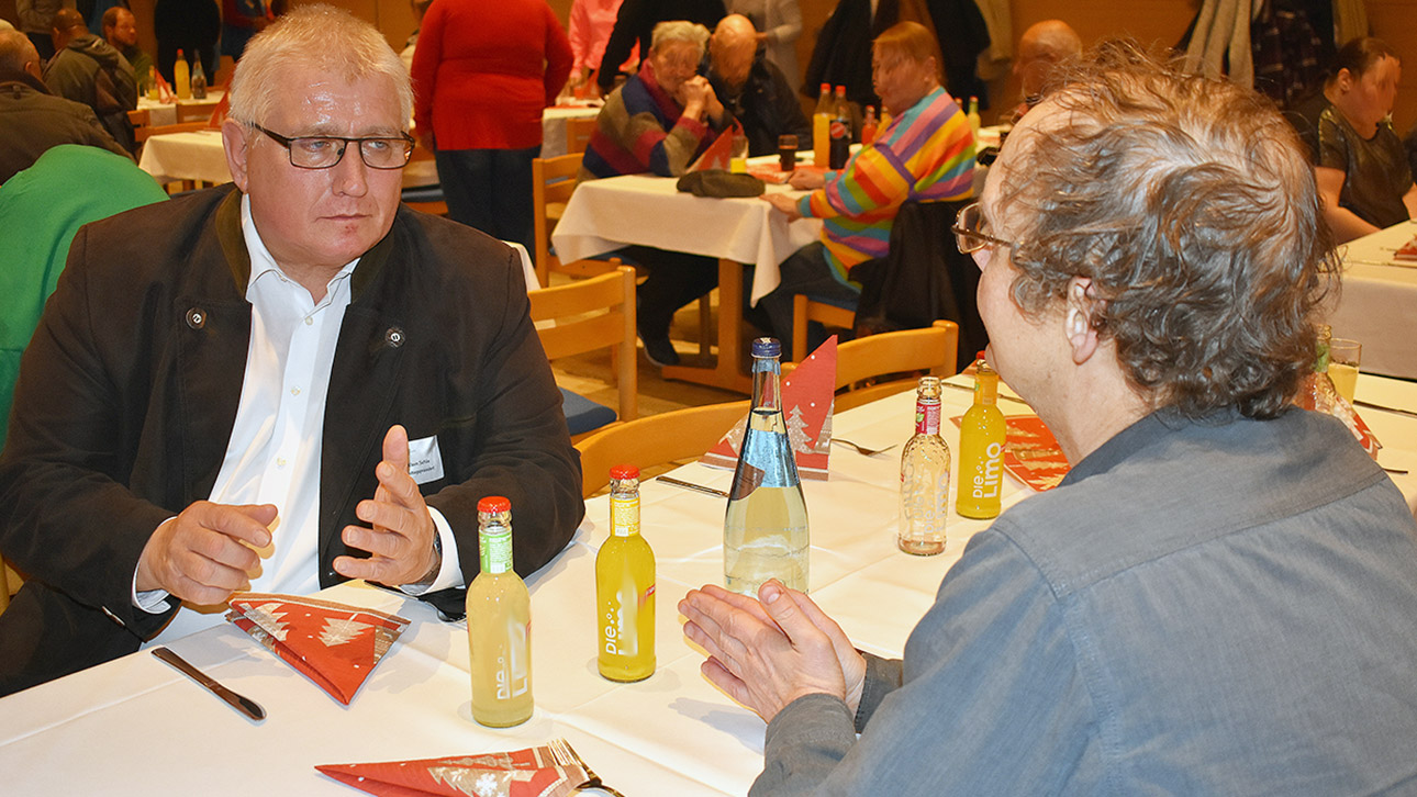 Landtagspräsident Schlie sitzt dem Neunmünsteraner Harry Gutschmidt an einer Tafel mit weißem Tischtuch gegenüber.