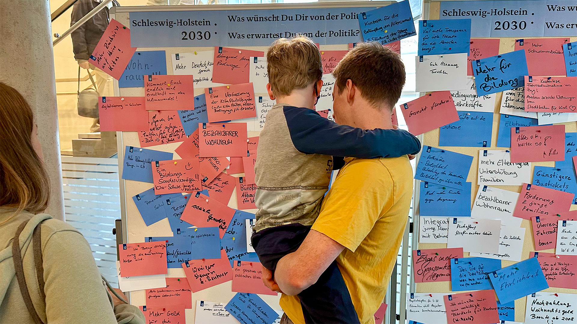 Menschen stehen vor der Pinnwand im Rahmen des Tages der offenen Tür im Landtag