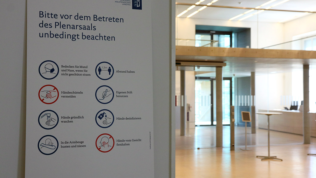 Vor dem Plenarsaal hängt ein Schild mit Hygiene-Regeln. 