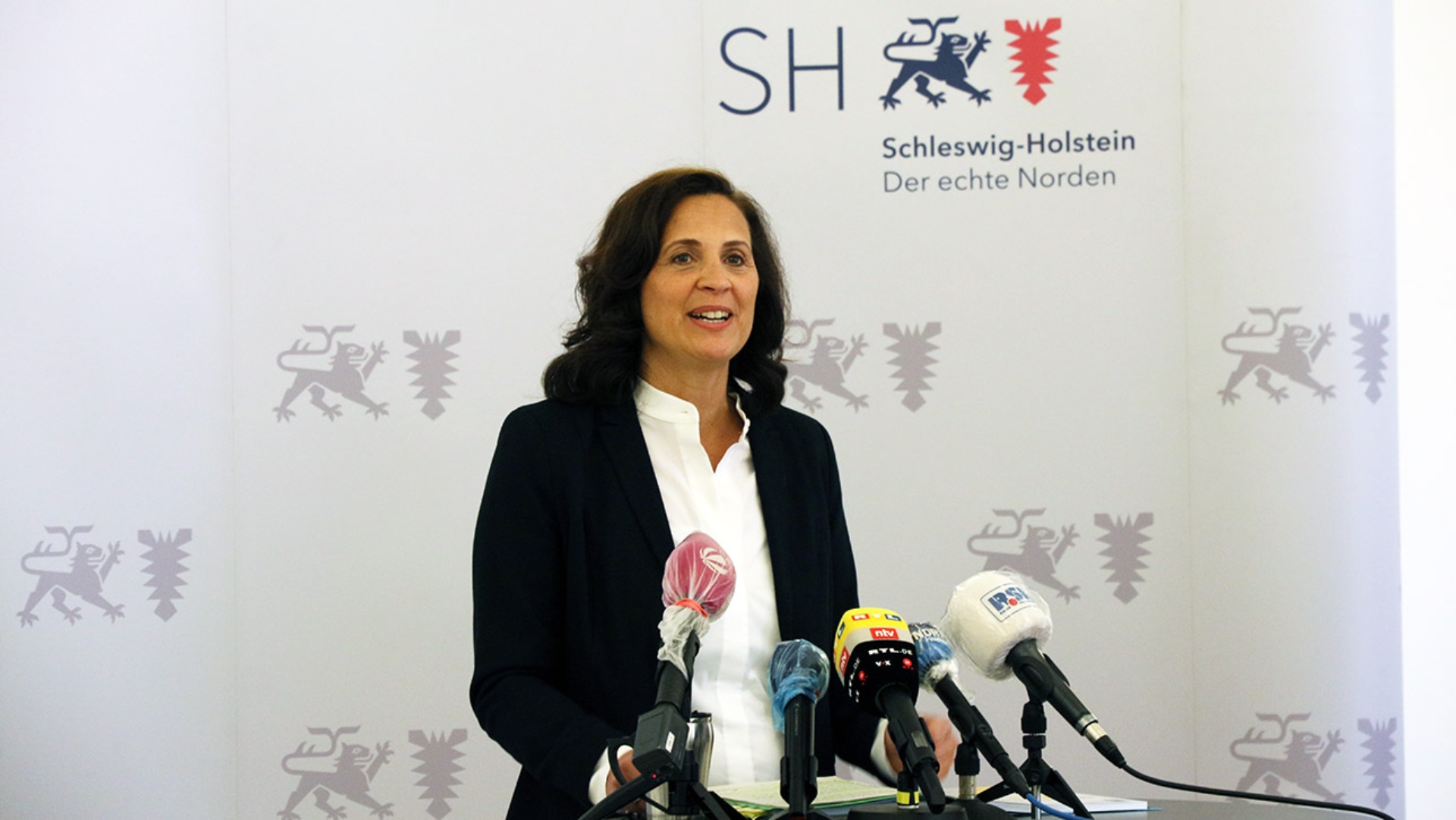 Die Bürgerbeauftragte El Samadoni stellt auf einer Pressekonferenz ihren aktuellen Tätigkeitsbericht vor. Vor ihr sind mehrere Mikrofone aufgebaut.