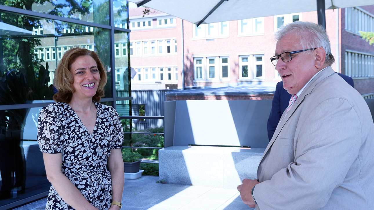 Die bulgarische Botschafterin Elena Shekerletova und Landtagspräsident Klaus Schlie unterhalten sich unter einmen großem Sonnenschirm auf der Terrasse des Gästehauses.